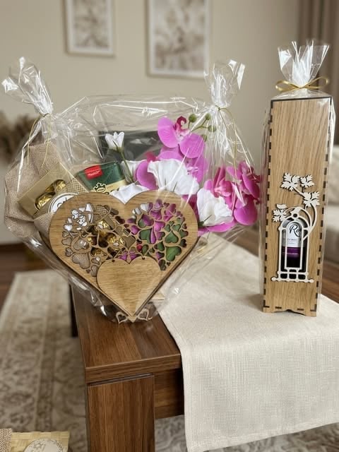 Decorative gift baskets with pink flowers, cellophane wrapping, and wooden boxes on a table
