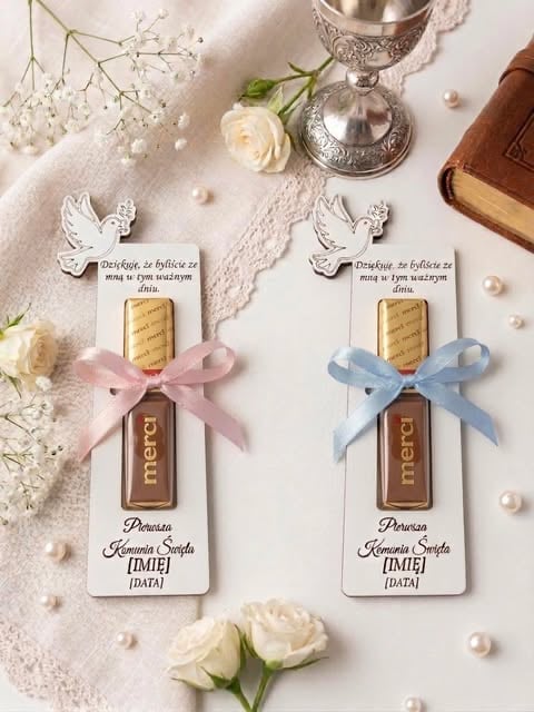 Two decorative gift tags with angel charms, ribbons, and chocolate bars on a white lace fabric with white roses, babys breath, and pearls