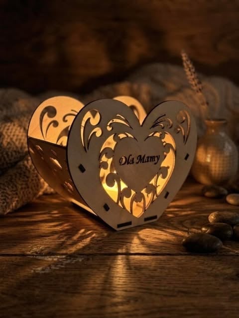 Decorative heart-shaped lantern with cut-out patterns and Oh Mamy text, glowing with warm light on wooden surface